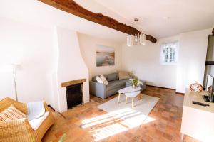ein Wohnzimmer mit Sofa und Kamin in der Unterkunft Le Petit Hômage in Lanaken