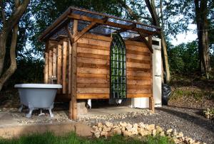 a wooden shed with a bath tub in the yard at Tiny bubble Tree Tent in private woodland in Kent