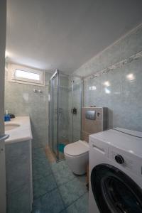 a bathroom with a shower toilet and a washing machine at Seafarer's Suite by Filos Inc in Galaxidi +31 photos
