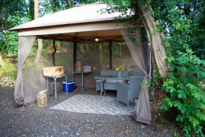 a gazebo with a table and chairs under it at Tiny bubble Tree Tent in private woodland in Kent