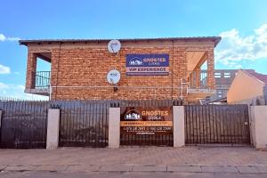 a brick building with a fence in front of it at Gnostes Lodge Vosloorus in Vosloorus