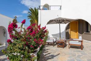 a patio with pink flowers and an umbrella at Senses Hotel - Adults Only in Bodrum City