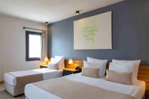 a hotel room with two beds and a painting on the wall at Senses Hotel - Adults Only in Bodrum City
