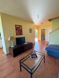 a living room with a blue couch and a glass table at Villa Torremirona Resort Palmeras in Navata