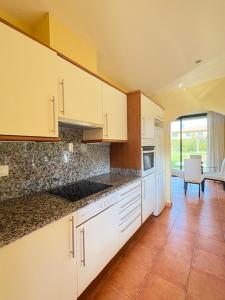 a kitchen with white cabinets and a counter top at Villa Torremirona Resort Palmeras in Navata