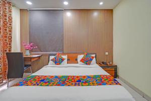 a bedroom with a large bed and a desk at FabHotel HM Inn in Lucknow