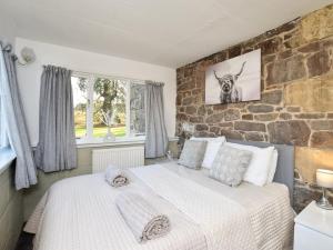 a bedroom with two beds and a stone wall at 7 Bed in Cupar oc-81242 in Cupar