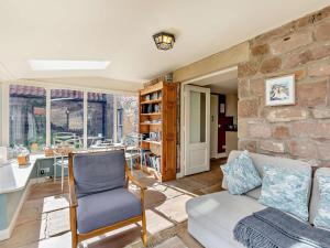 a living room with a couch and a stone wall at 4 Bed in Chathill oc-93702 in Ellingham