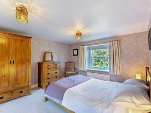 a bedroom with a bed and a window and a dresser at 4 Bed in Chathill oc-93702 in Ellingham