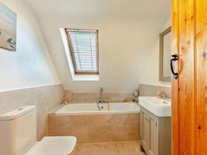 a bathroom with a tub and a toilet and a sink at 4 Bed in Chathill oc-93702 in Ellingham +21 photos