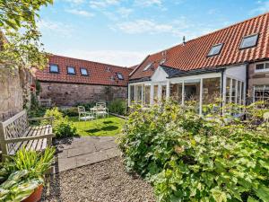 a garden with a bench and a house at 4 Bed in Chathill oc-93702 in Ellingham