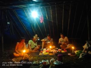 a group of people sitting around a tent with lights at Batu Katak Indah - Leuser Trekking in Binjai