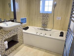 a bathroom with a bath tub and a sink at Haddon House Hotel in Bridport