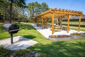 ein Grillplatz und Picknicktische in einem Park in der Unterkunft 1st Place Hotel Decatur I-20 East Atlanta in Decatur