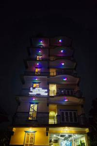 ein hohes Gebäude mit violetten und blauen Lichtern in der Unterkunft Hotel Global Unique in Pokhara