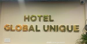ein Schild für eine globale Hotelinitiative an einer Wand in der Unterkunft Hotel Global Unique in Pokhara