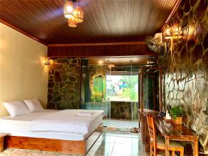 a bedroom with a bed and a desk in a room at Rocky Mountain Ecology in Xuân Sơn
