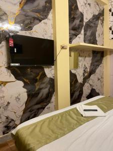 a bedroom with a bed with a tv on a wall at Royal Inn in Lucknow
