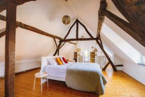 ein Schlafzimmer mit einem weißen Bett auf dem Dachboden in der Unterkunft Le Petit Hômage in Lanaken