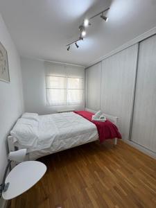 a bedroom with a bed with a red blanket at Dalí City Apartamento in Figueres