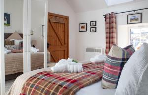 a bedroom with a bed and a mirror at The Cottage, 7 Struanmore in Struan