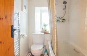 a bathroom with a toilet and a tub and a window at The Cottage, 7 Struanmore in Struan +54 photos