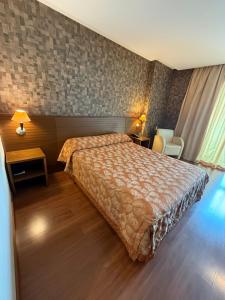 a hotel room with a bed and two chairs at Master Plaza Hotel in Barbacena +15 photos