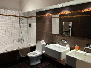 a bathroom with a tub and a toilet and a sink at Hôtel La Gibecière in Lohéac +19 photos