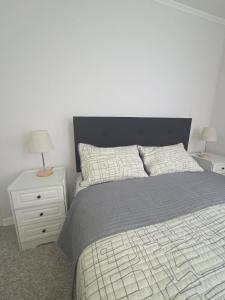 a bedroom with a bed and a nightstand with two lamps at Pacific blue cómodo y familiar in La Serena