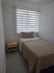 a bedroom with a large bed and a window at Pacific blue cómodo y familiar in La Serena