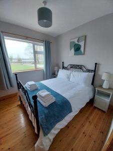 a bedroom with a large bed and a window at Cootehall in Boyle +3 photos