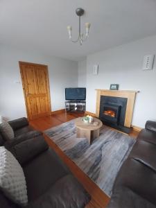 a living room with a couch and a fireplace at Cootehall in Boyle