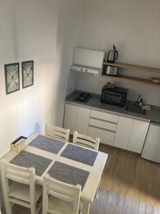 a kitchen with a table and chairs in a room at Departamentos Galarza Alojamiento en Concepción del Uruguay in Concepción del Uruguay