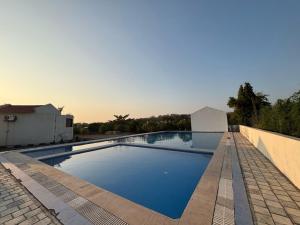 a swimming pool with blue water in a backyard at Vanray Farm And Resort in Talala
