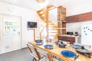 a kitchen with a wooden table with blue dishes on it at La Maison du Bonheur au Coeur d'Etretat in Étretat +12 photos