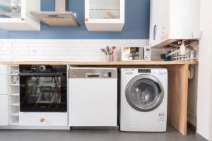 a kitchen with a washer and dryer under a counter at La Maison du Bonheur au Coeur d'Etretat in Étretat