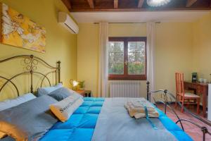 a bedroom with a bed with blue sheets and a window at B&B Gassa d'Amante in Capoterra
