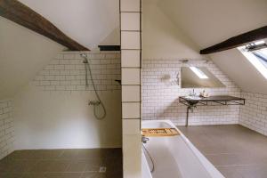 ein Badezimmer im Dachgeschoss mit Dusche und Badewanne in der Unterkunft Le Petit Hômage in Lanaken + 21 Fotos