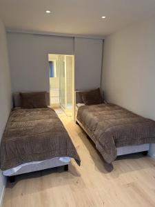 a bedroom with two beds and a mirror at Cosy Seahouse in Knokke-Heist