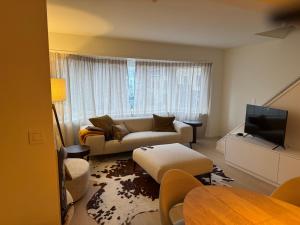 a living room with a couch and a tv at Cosy Seahouse in Knokke-Heist +1 photo