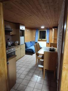 a kitchen and living room with a table and a couch at ANEMA Ferienwohnung in Bayerisch Eisenstein