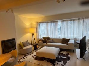 a living room with a white couch and a window at Cosy Seahouse in Knokke-Heist