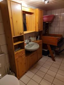 a bathroom with wooden cabinets and a sink at ANEMA Ferienwohnung in Bayerisch Eisenstein +24 photos