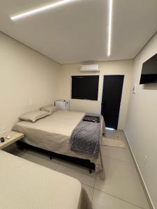 a bedroom with a bed and a tv in it at Suítes Pousada Canaã in Araxá