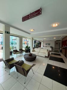 a lobby with a living room with a couch and chairs at Master Plaza Hotel in Barbacena