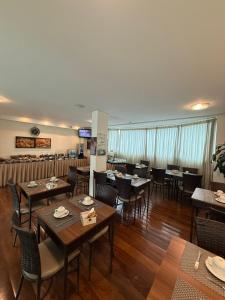 a dining room with wooden tables and chairs at Master Plaza Hotel in Barbacena