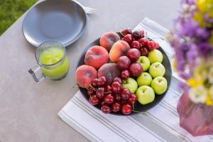 a plate of fruit on a table with a drink at Wooden villa with superpool and sauna, 30 min from Yerevan in Tsakhkashen +57 photos