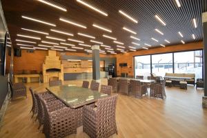 a dining room with tables and chairs and a fireplace at Wooden villa with superpool and sauna, 30 min from Yerevan in Tsakhkashen