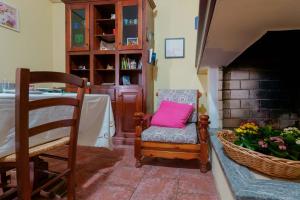 a living room with a chair with a pink pillow at B&B Gassa d'Amante in Capoterra