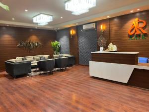a lobby with a waiting room with couches and a counter at Aair Hotel And Resorts in Karnal